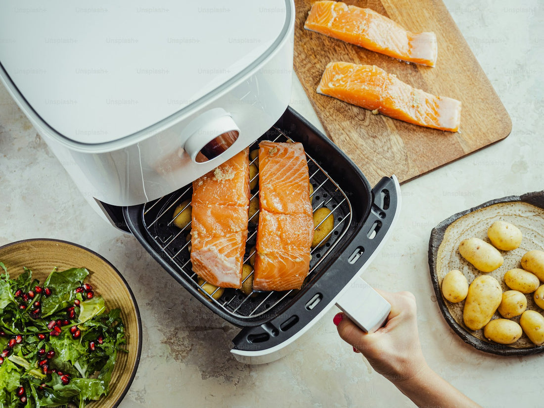 Person placing salmon into an air fryer basket in a modern kitchen