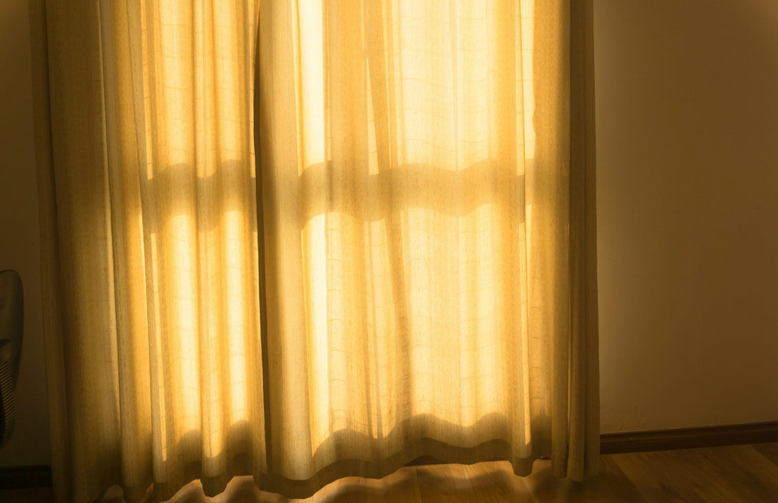 White curtains hanging beside a bright window during daytime