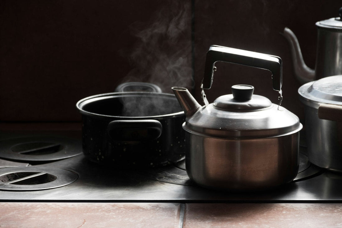 Stainless steel electric kettle beside a ceramic mug on a clean kitchen counter