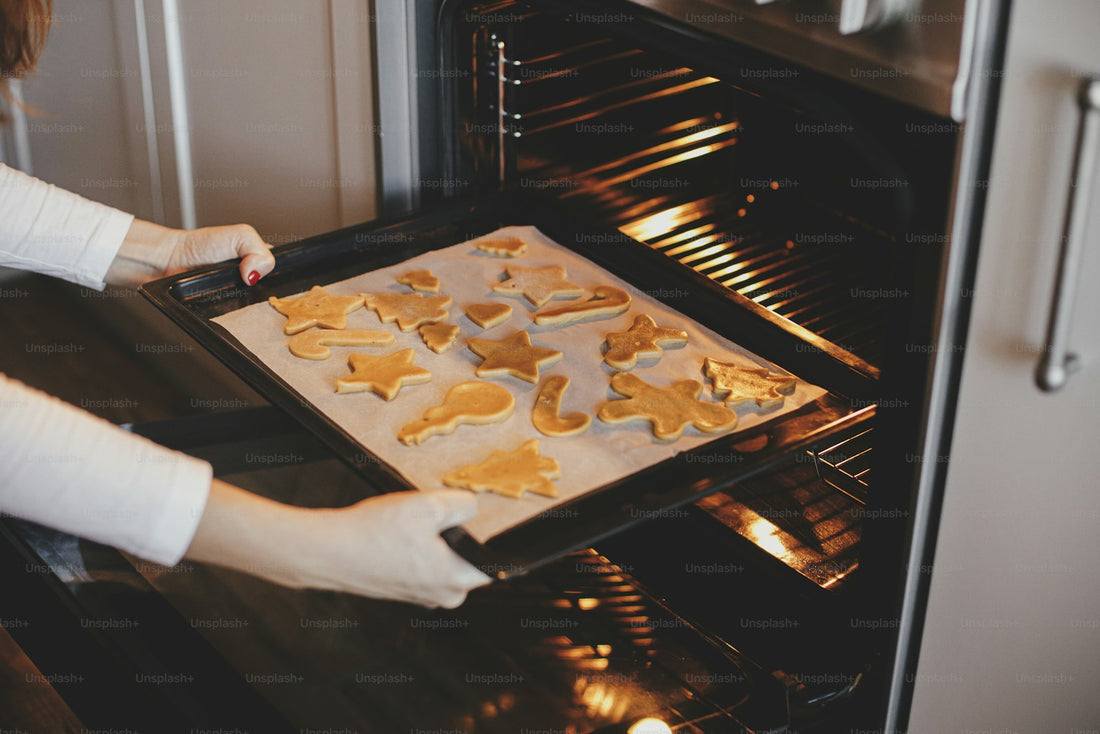 Person sliding a baking sheet into an oven with metal racks