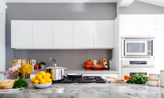 A clean modern white kitchen with a marble island