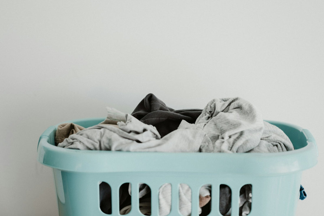 White laundry resting inside a blue plastic laundry basket