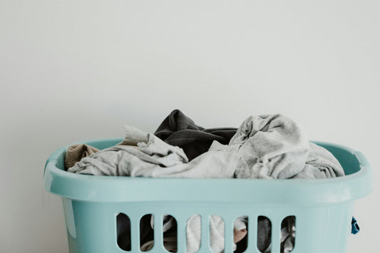 White laundry resting inside a blue plastic laundry basket