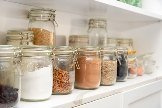 Organized pantry shelves with food stored in clear glass jars