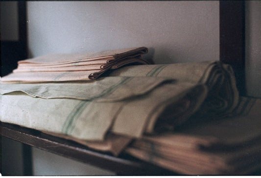 Neatly folded linens arranged on a closet shelf