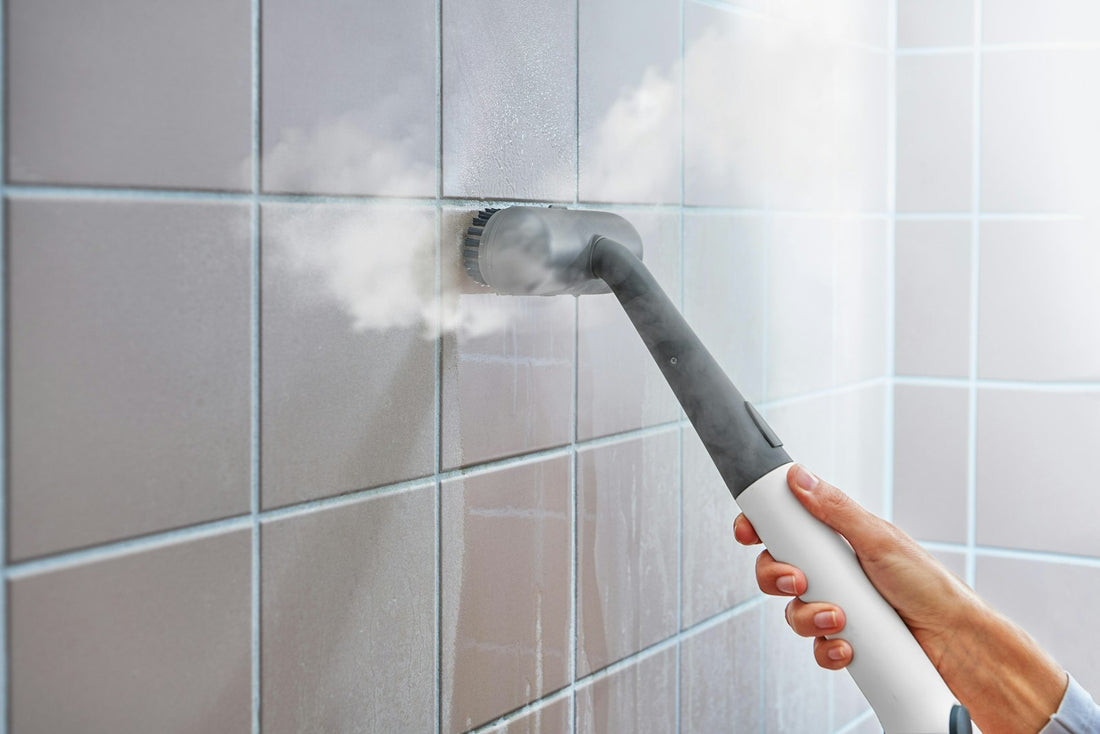 Steam cleaner sanitizing a tiled bathroom wall