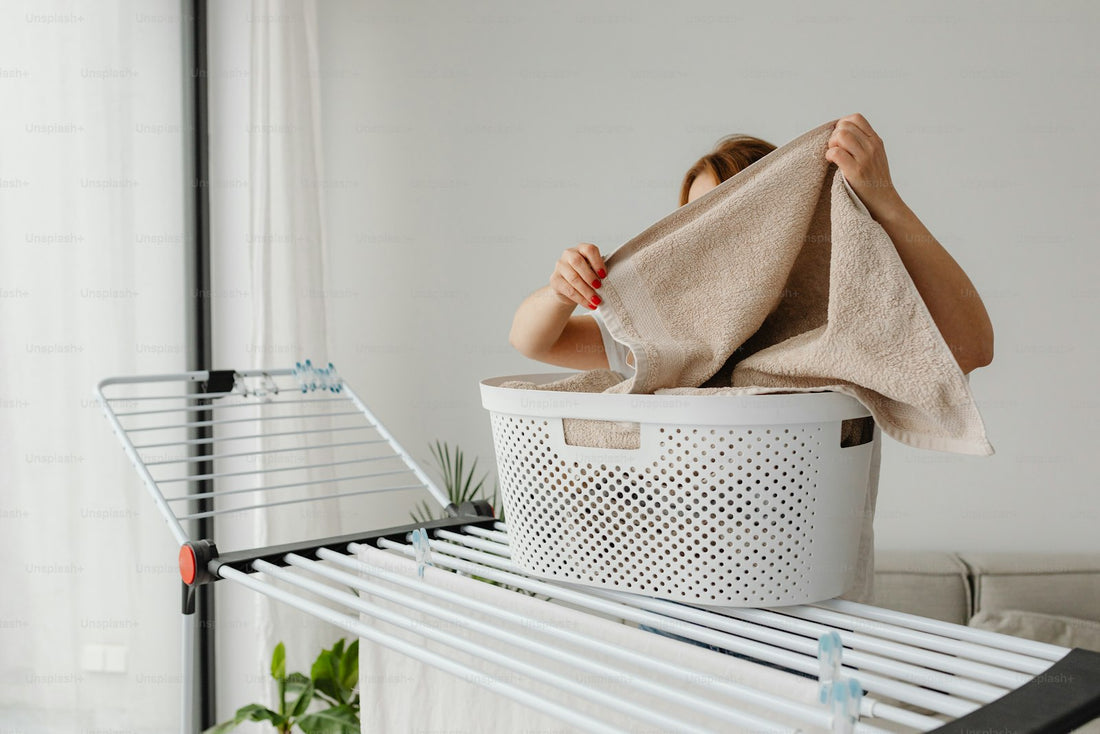 A woman arranging laundry for air drying in a bright home