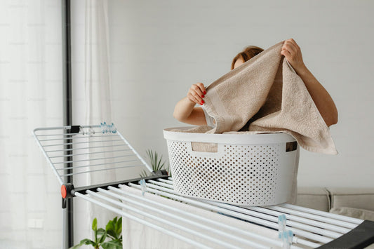 A woman arranging laundry for air drying in a bright home