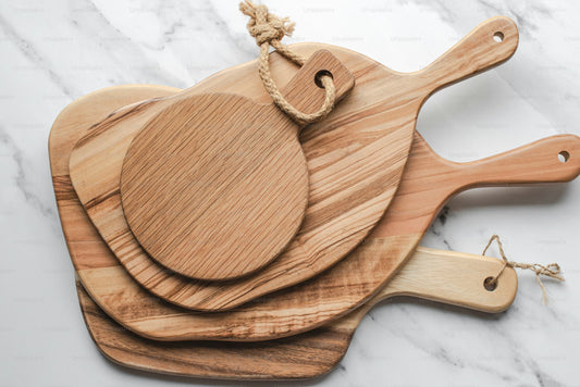Three wooden cutting boards arranged on a marble kitchen counter