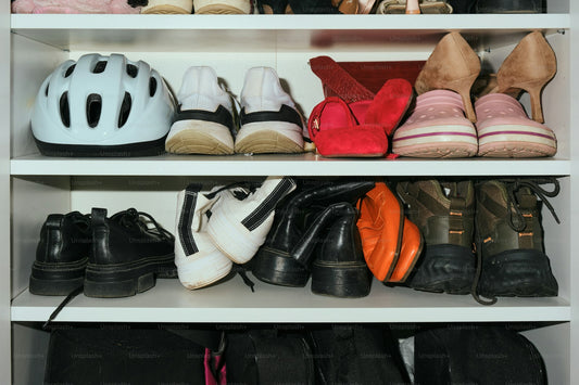 Shoes and a helmet arranged neatly on open closet shelves